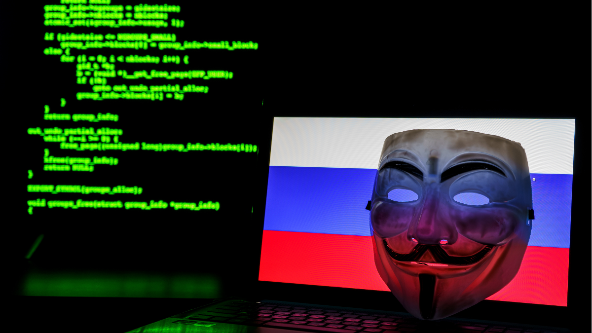 Uma máscara de Hacker em frente a tela de um computador com as cores da bandeira russa - Startups