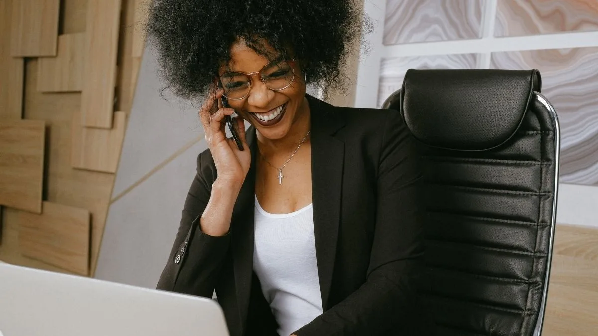 Mulher sentada na cadeira falando no celular - Startups