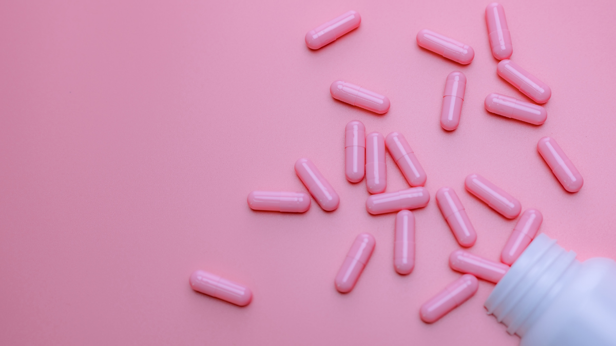 Comprimidos rosa de remédio ao lado de um frasco branco - Startups