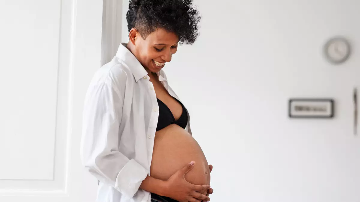 Foto de uma mulher grávida segurando a barriga - Startup